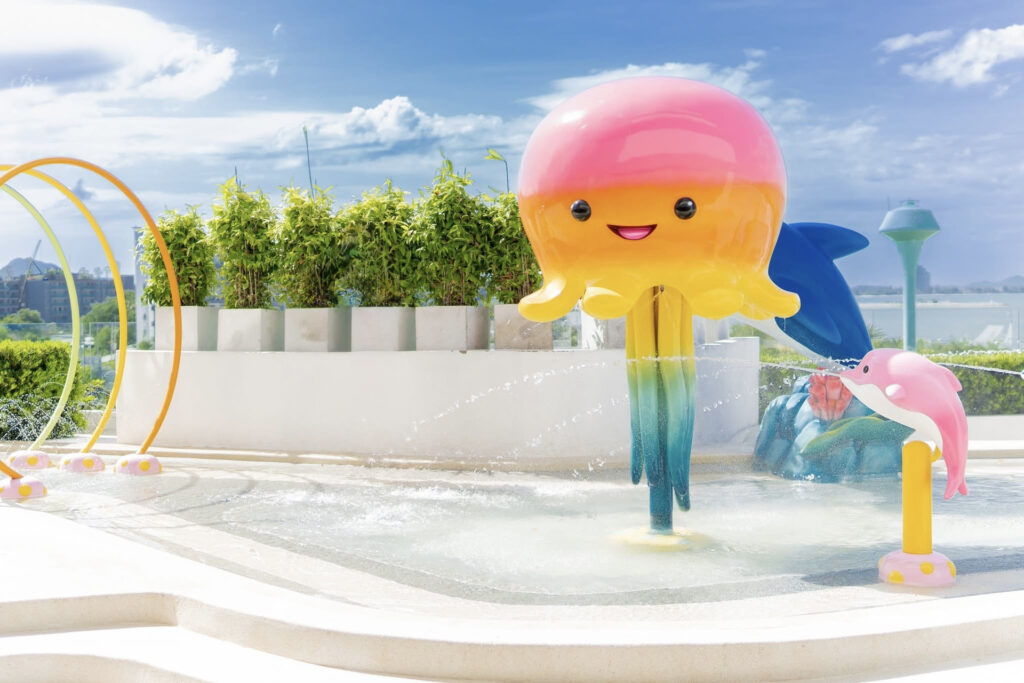 Jellyfish and dolphin spray features over the patterned PebbleCrete splash pad at Ocean Marina Resort