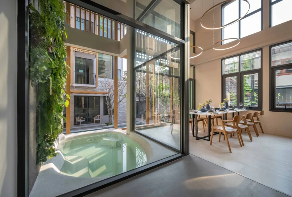 Cool Grey PebbleCrete bath beside glazed living spaces at Shan Villa Sukhumvit