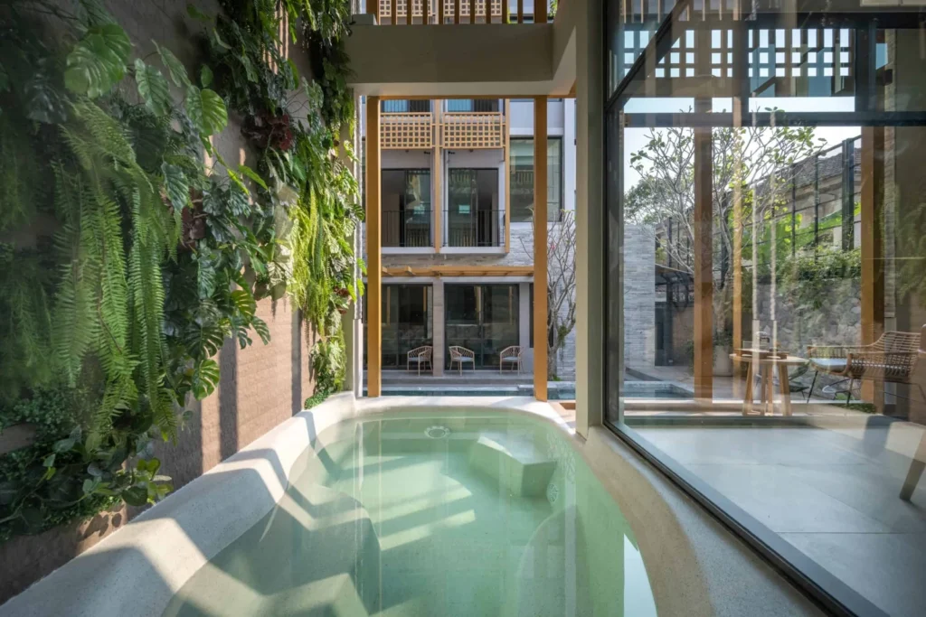 Sculpted Cool Grey bath beside a planted wall at Shan Villa Sukhumvit