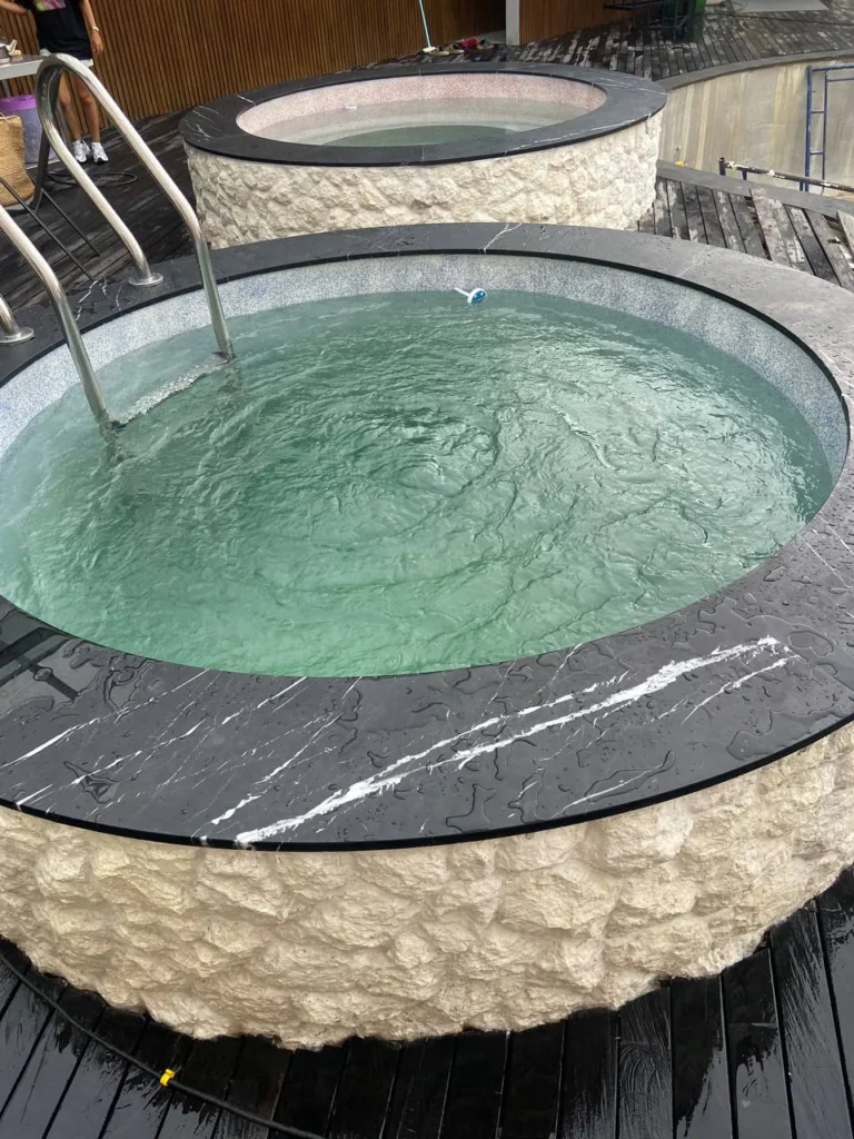Two circular plunge pools at ZIMA Spa with contrasting custom PebbleSupreme finishes