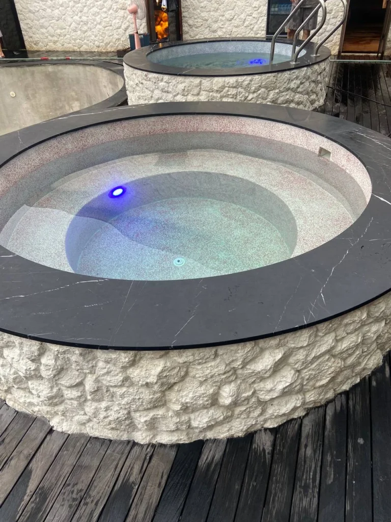 Contrasting glass aggregate finishes in two circular plunge pools at ZIMA Spa