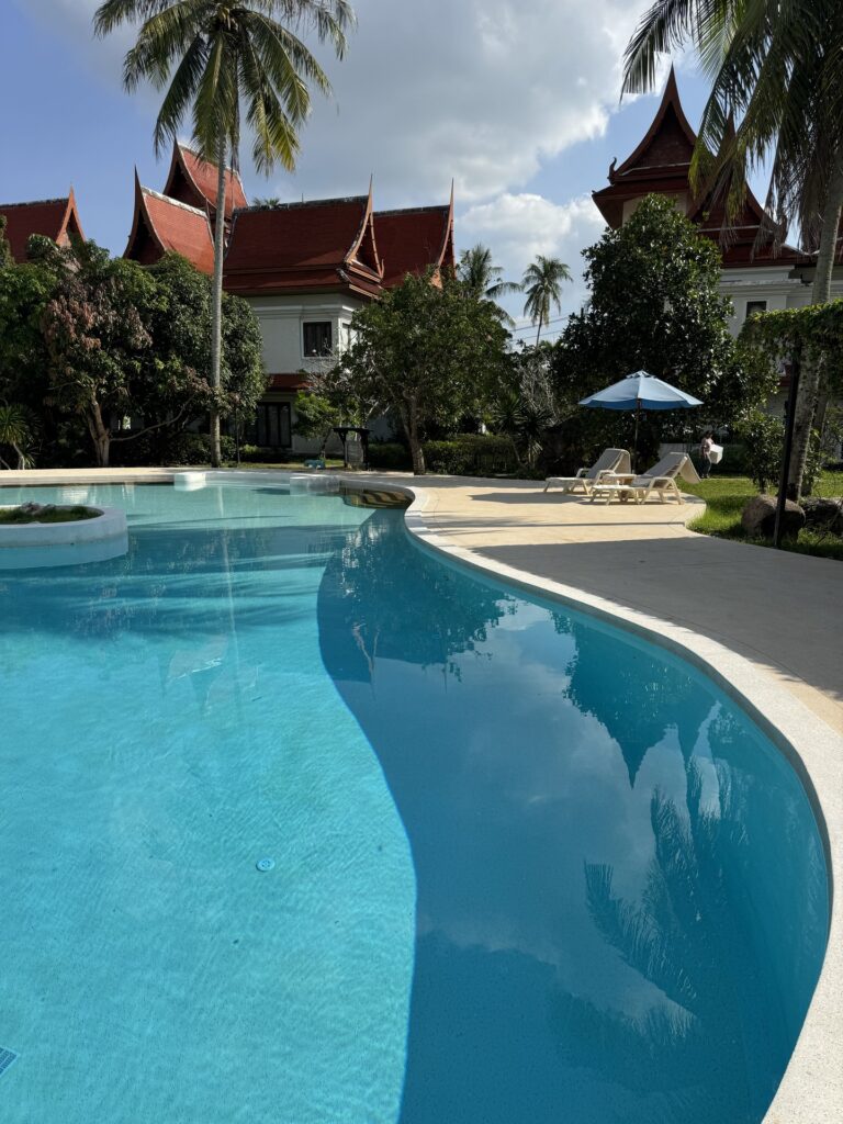 The curved pool edge leads towards loungers and tropical planting beside the shared lagoon pool.
