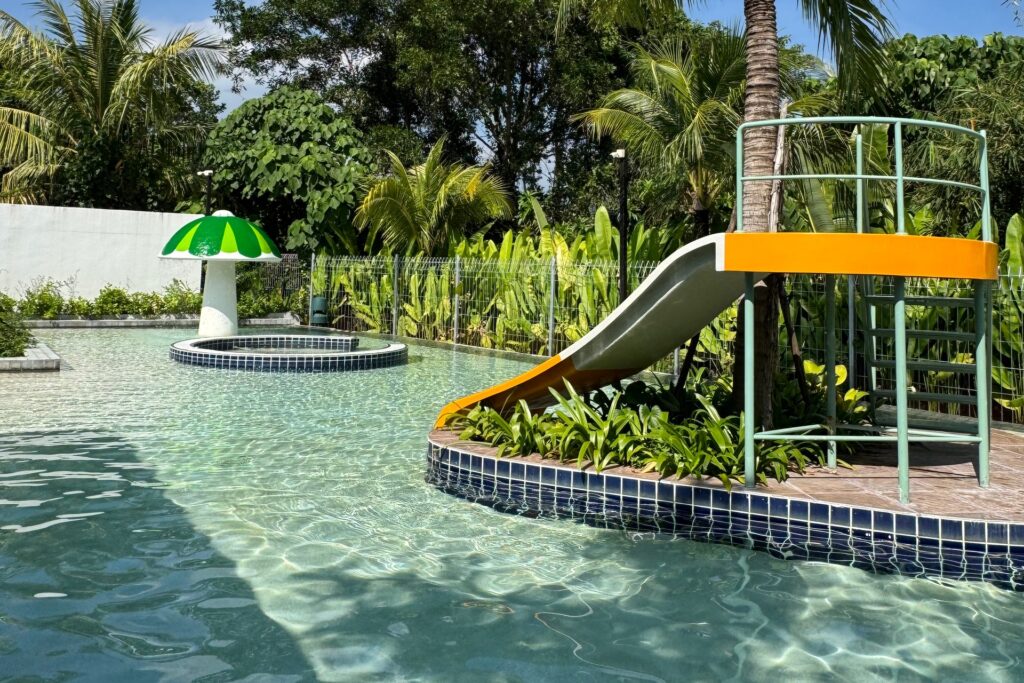 Slide beside a palm island and mushroom fountain at Sugar Marina LAGOON Splash Park in Nai Yang, Phuket.