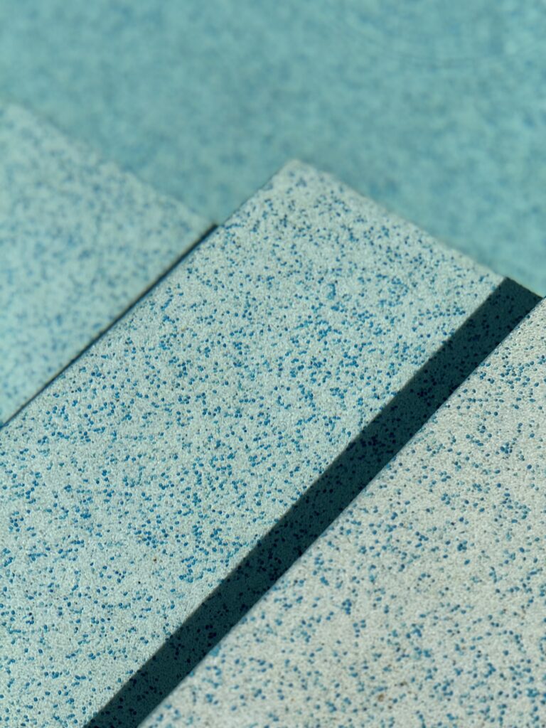 Close-up of the blue aggregate finish on submerged pool steps at Villa Tantawan