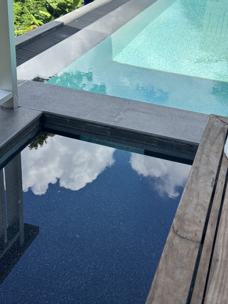 Dark finished water feature beside the blue pool at Villa Tantawan
