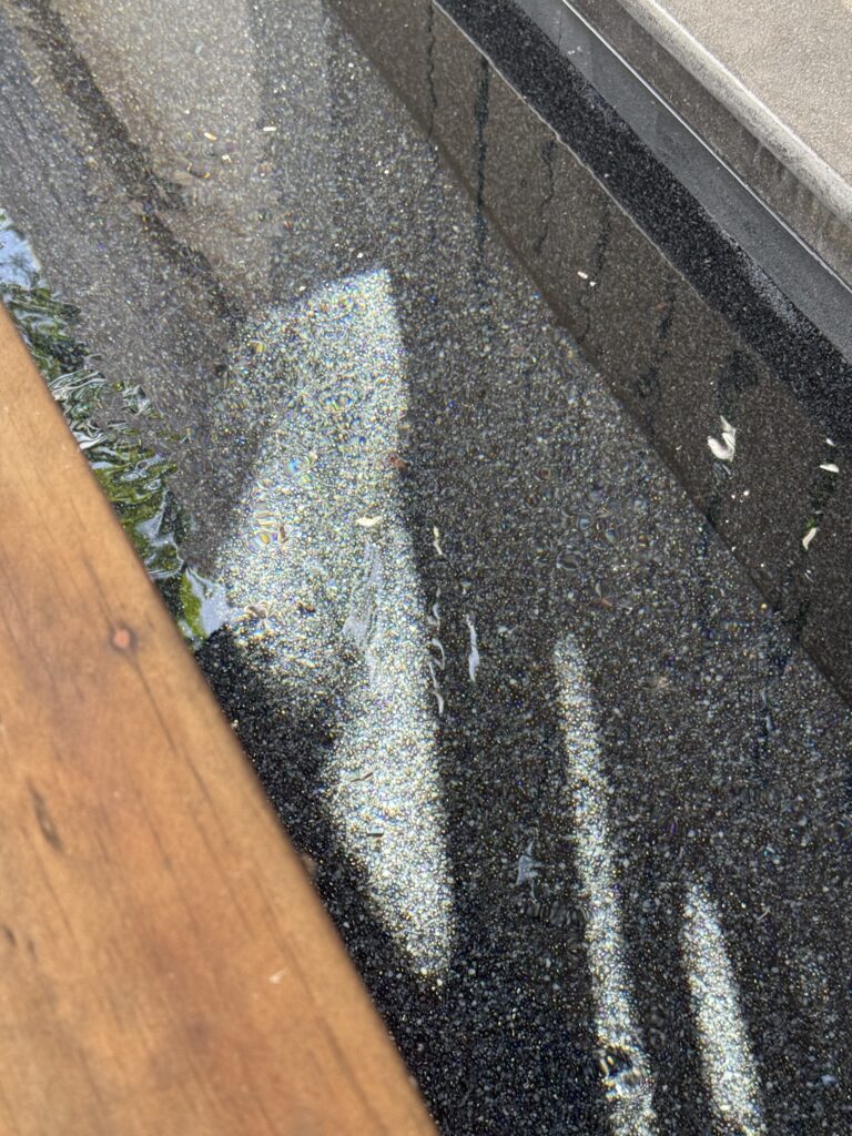 Close-up of the dark aggregate finish under water at Villa Tantawan
